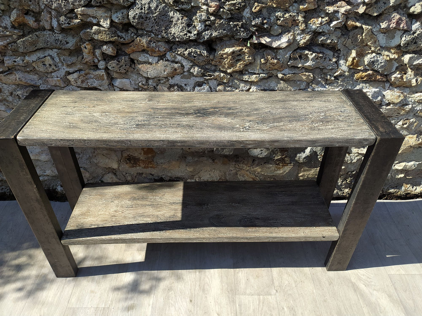 Grande console entièrement en acier, patine façon grise cerisée avec deux étagères, vue de dessus et de face contre mur