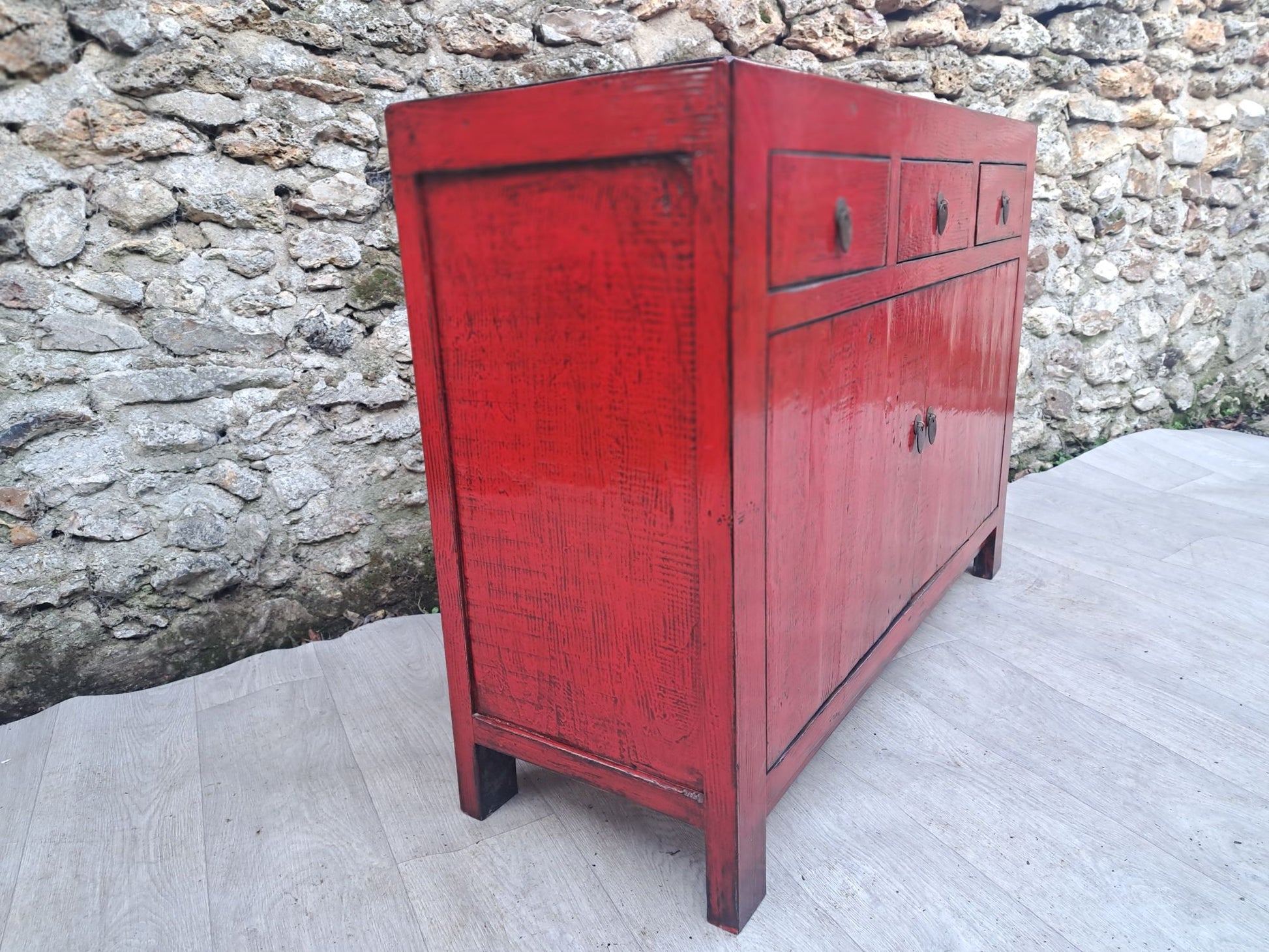 Moyen meuble rouge vieilli laqué 3 tiroirs et 2 portes, côte gauche